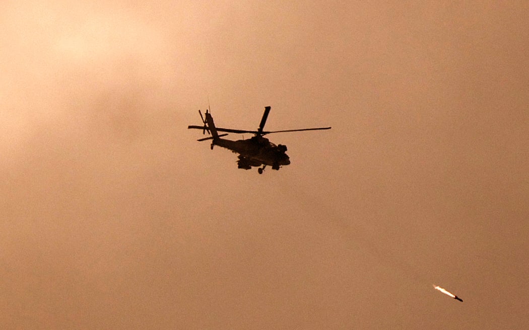 A picture taken from a position in southern Israel along the border with the Gaza Strip on December 29, 2023 shows an Israeli military helicopter firing a missile towards Gaza amid continuing battles between Israel and the militant group Hamas.