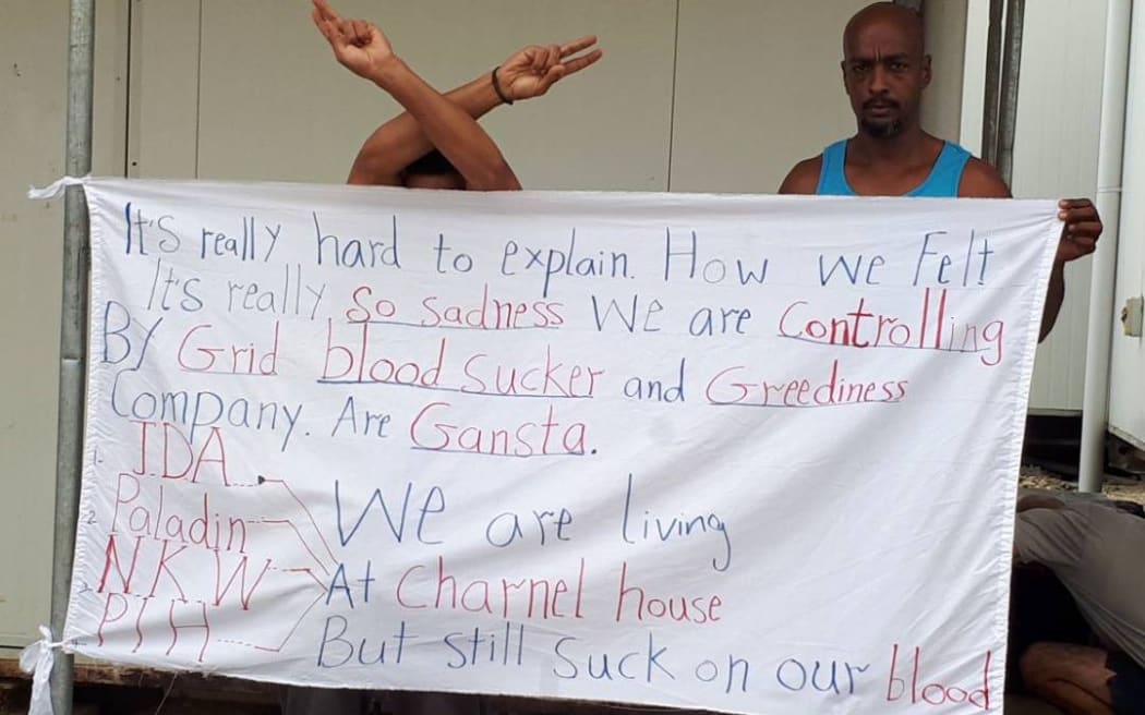 Bashir Osman displays one of his protest banners.