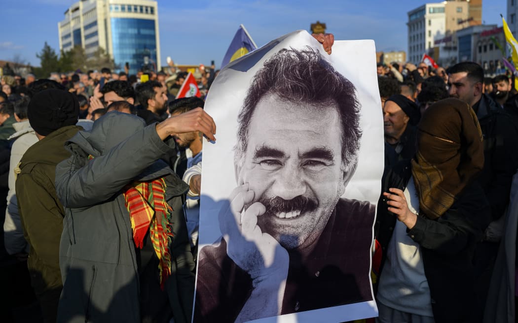 Supporters display a poster depicting jailed leader of the Kurdistan Workers' Party (PKK) Abdullah Ocalan, 75, after he called on the Kurdistan Workers' Party (PKK) to disarm and dissolve itself in Diyarbakir, southeastern Turkey. (Photo by Yasin AKGUL / AFP)