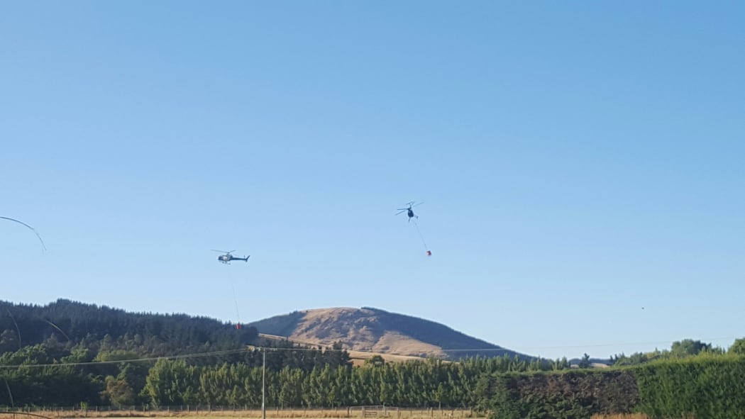 Helicopters with monsoon buckets tackle the Port Hills fire.
