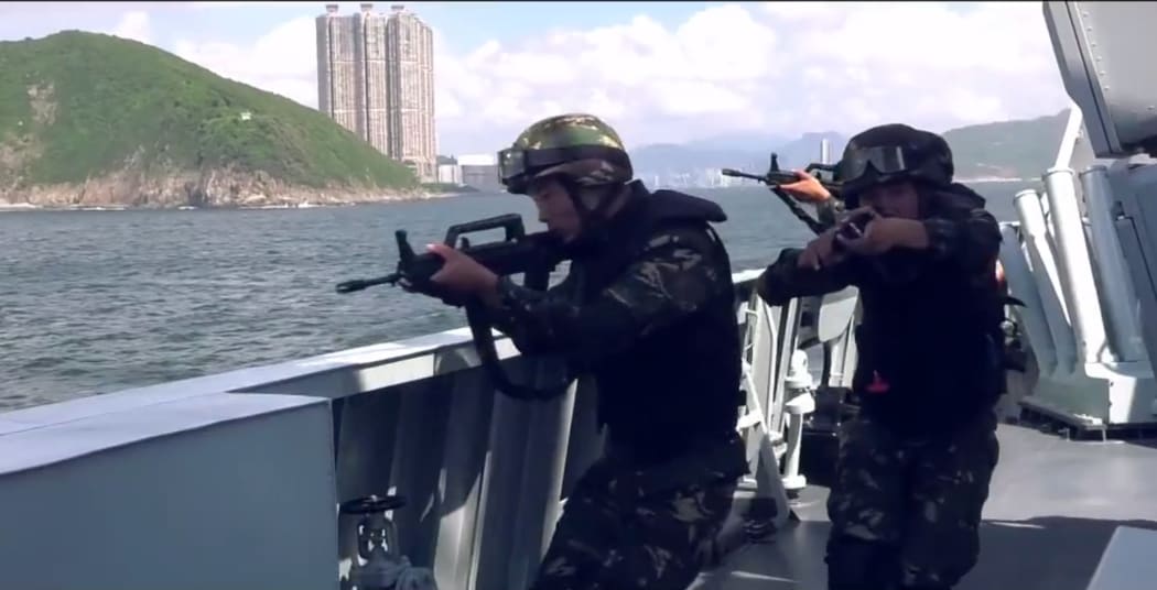 This screengrab taken from undated handout three-minute promotional video received on August 1, 2019 from China's People's Liberation Army (PLA) Hong Kong Garrison shows armed PLA soldiers on a boat during a drill in Hong Kong waters.