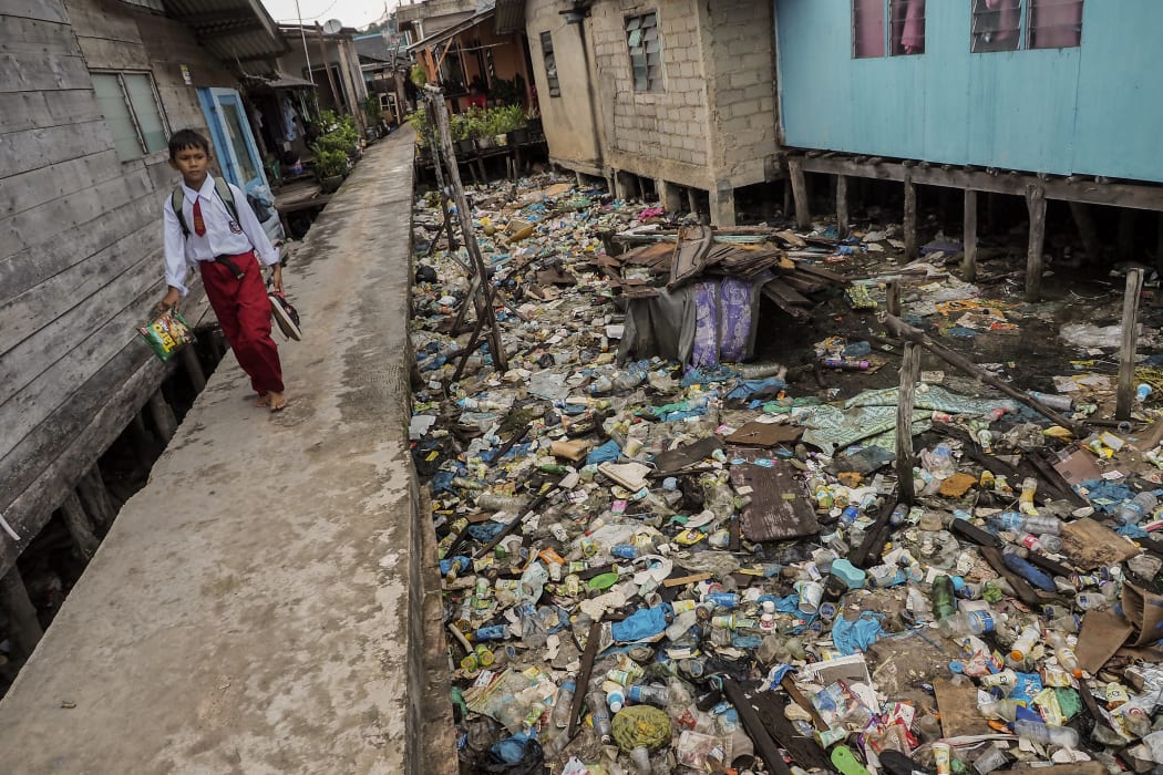 Household garbage disposed of into the sea at low tide accumulates under the houses of residents in the Riau island of Batam, Indonesia.