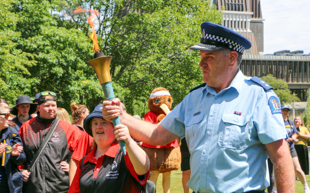 Samantha McLachlan and Superintendent Lane Todd jointly hold the torch as the torch run gets underway at Victoria Square.