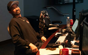 Emmy award winning sound editor Martin Kwok is sitting at his sound desk in a studio