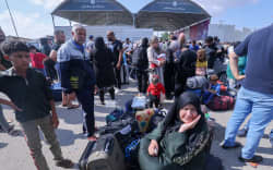 Palestinians, some with foreign passports hoping to cross into Egypt and others waiting for aid wait at the Rafah crossing in the southern Gaza strip, on October 16, 2023. The death toll from Israeli strikes on the Gaza Strip has risen to around 2,750 since Hamas’s deadly attack on southern Israel last week, the Gaza health ministry said October 16. Some 9,700 people have also been injured as Israel continued its withering air campaign on targets in the Palestinian coastal enclave, the Hamas-controlled ministry added. (Photo by Mohammed ABED / AFP)