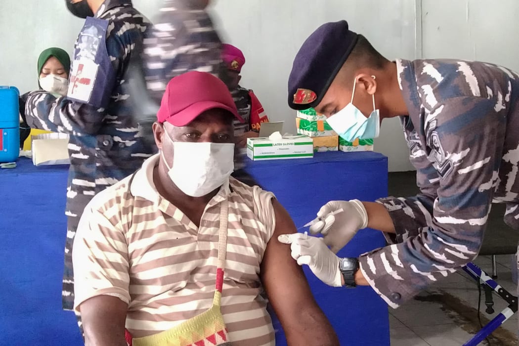 A Papuan man receives a dose of the Sinovac Covid-19 coronavirus vaccine conducted by Indonesian navy medical team at Sorong seaport, in Sorong, West Papua, July 18, 2021.