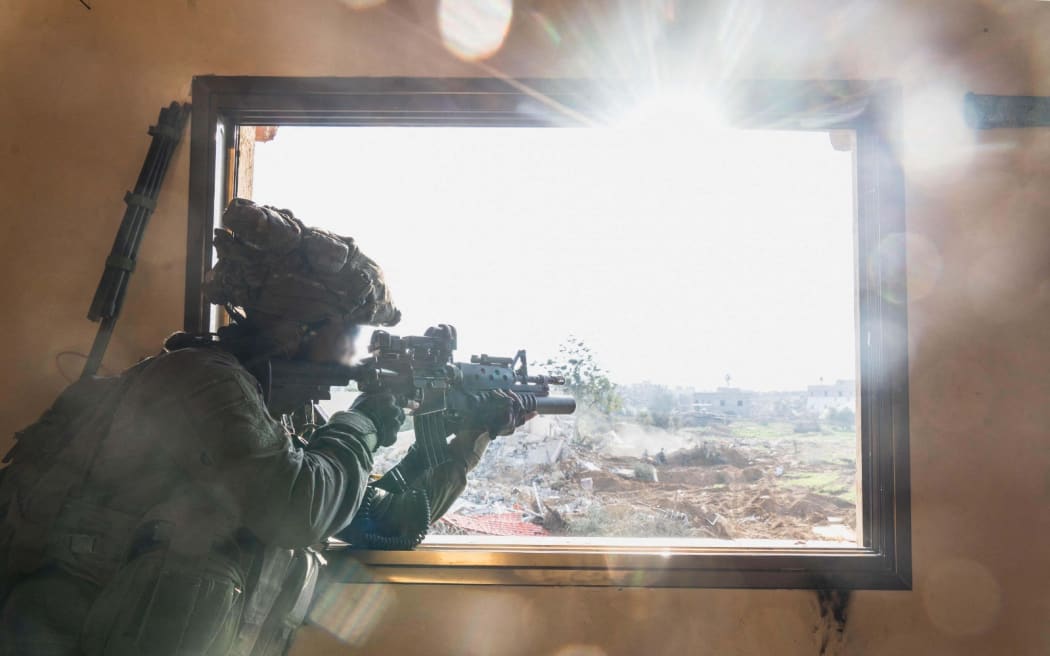 This handout picture released by the Israeli army on January 18, 2024 shows an Israeli soldier keeping position during operations in Khan Yunis area in the southern Gaza Strip amid continuing battles between Israel and the Palestinian militant group Hamas. (Photo by Israeli Army / AFP) / === RESTRICTED TO EDITORIAL USE - MANDATORY CREDIT "AFP PHOTO / Handout / Israeli Army' - NO MARKETING NO ADVERTISING CAMPAIGNS - DISTRIBUTED AS A SERVICE TO CLIENTS ==
