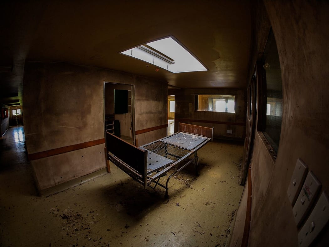 A bed sits alone in the isolation ward at Tokanui Psychiatric Hospital.jpg
