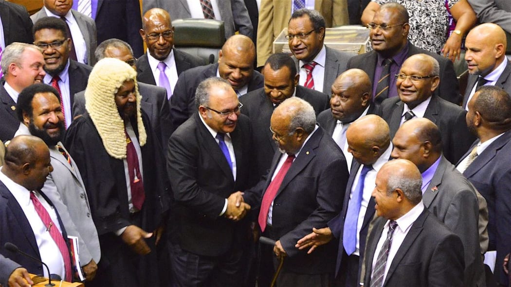 Sir Michael Somare (centre, red tie) is congratulated by Peter O'Neill and other MPs on his last attendance in the Papua New Guinea parliament, 4 April 2017.