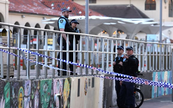 Police inspect at the scene of a shooting at Bondi Beach in Sydney on December 15, 2025. Towels, bags and baby strollers littered Sydney's Bondi Beach -- the harrowing aftermath of the country's worst mass shooting in years. Eleven people were killed and many more rushed to hospital in what Australian police are now calling a "terrorist" attack targeting the city's Jewish community during a celebration of Hanukkah. (Photo by DAVID GRAY / AFP)