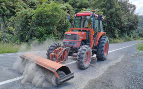 A contractor puts the finishing touches to new seal on SH43 at Tangarakau Gorge.