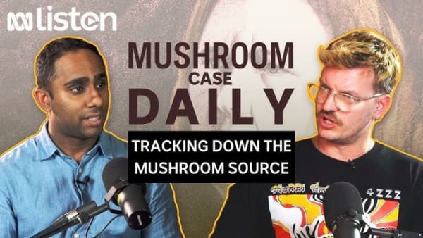 Two men look at each other with microphones below their faces.