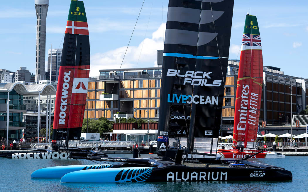 New Zealand SailGP Team F50 catamaran with the fleet moored in the harbour in front of the city skyline prior to a practice session ahead of The Rolex SailGP 2025 Championship ITM New Zealand Sail Grand Prix in Auckland, New Zealand. Thursday 16 January 2025. Photo: Felix Diemer for SailGP. Handout image supplied by SailGP