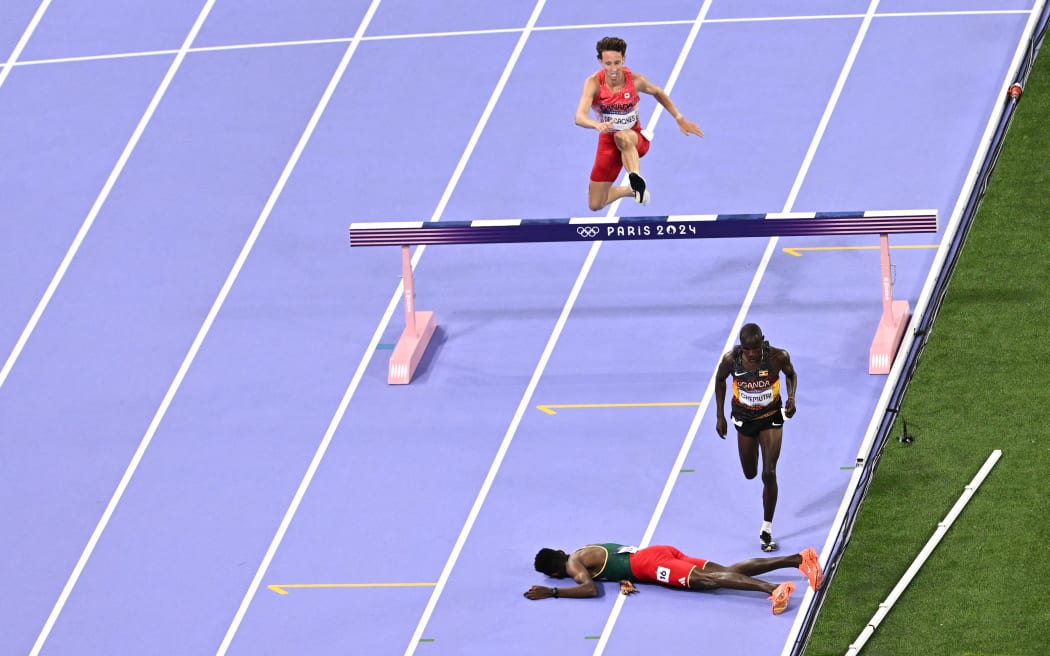 Ethiopia's Lamecha Girma lies on the track during the men's 3000m steeplechase final at the Paris Olympics.