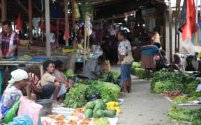 Papuan women sell produce in an old market in Sentani