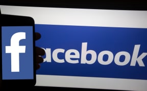 The logo of Facebook is seen on a smartphone.