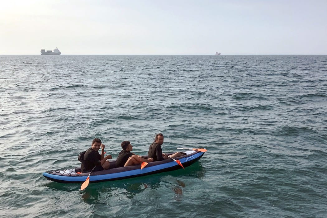 Three migrants who were attempting to cross The English Channel from France to Britain are seen as they drift in an inflatable canoe off the French coast at Calais on August 4, 2018, before being rescued.