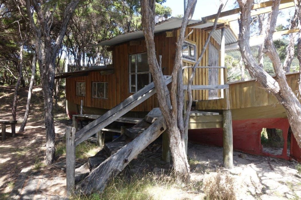 One of three dwellings on the beachfront property for sale at Awaroa is a re-fashioned boat. A crowd funding campaign has raised millions to purchase the land.15 February 2016.