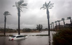 A car is partially submerged in floodwaters as Tropical Storm Hilary moves through the area on August 20, 2023 in Cathedral City, California. Southern California is under a first-ever tropical storm warning as Hilary impacts parts of California, Arizona and Nevada.