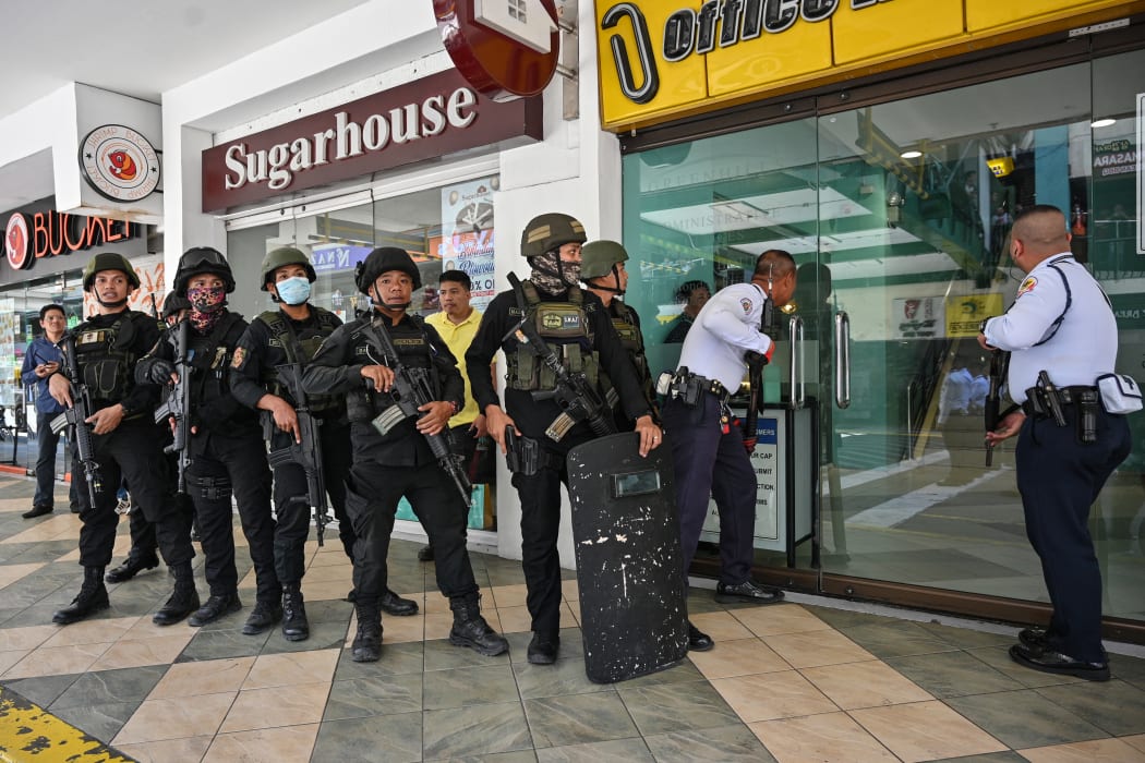 Members of a police SWAT team prepare to enter a mall after a hostage situation was reported in suburban Manila on 2 March, 2020.