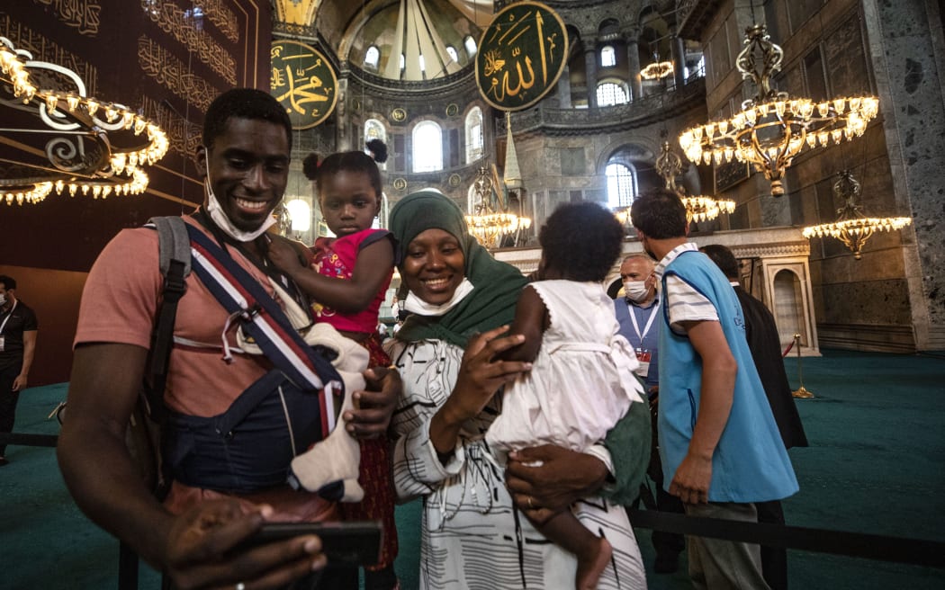 Joyful family posing inside Hagia Sophia with awe-inspiring architecture in the background.
