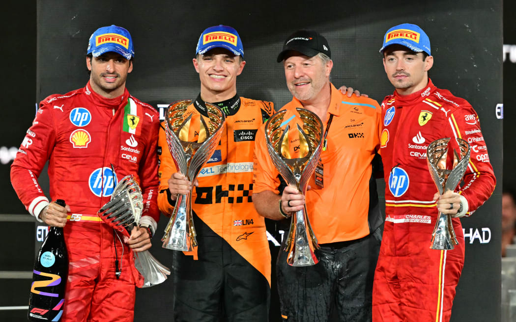 (From L) Ferrari's Spanish driver Carlos Sainz Jr., McLaren's British driver Lando Norris, McLaren's US principal Zak Brown and Ferrari's Monegasque driver Charles Leclerc celebrate on the podium after the Abu Dhabi Formula One Grand Prix,  2024.