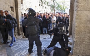 Israeli security forces immobilise a Palestinian man at an entrance to the al-Aqsa mosque  compound as others are prevented from entering, on April 15, 2022.