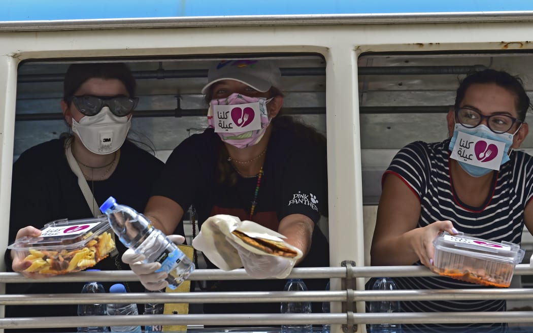 BEIRUT, LEBANON - AUGUST 07: Volunteers provide water and food for people who help to clean debris after a fire at a warehouse with explosives at the Port of Beirut led to massive blasts in Beirut, Lebanon on August 07, 2020.