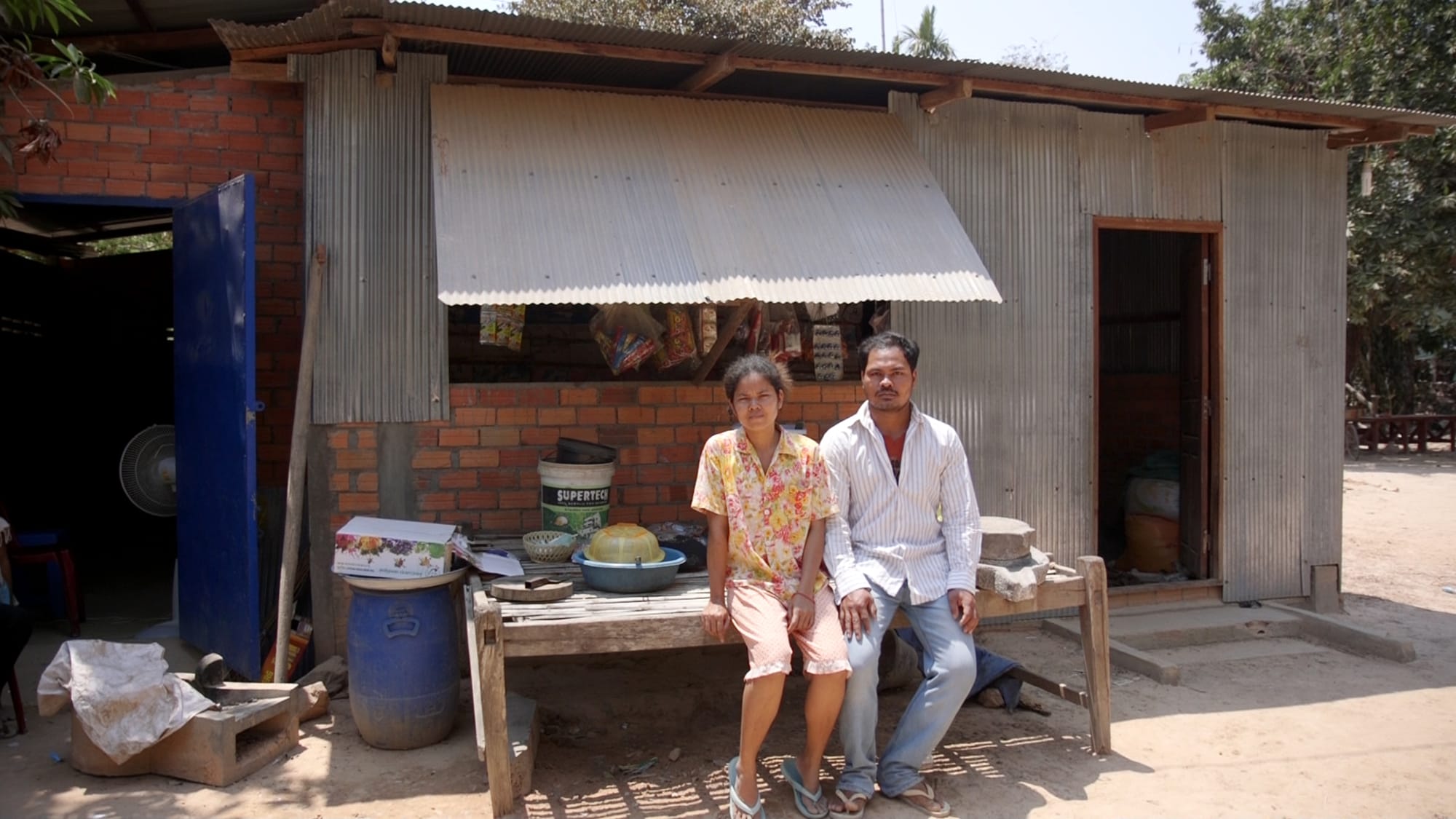 Thin Theng Ly and his wife outside the store where they sell snacks