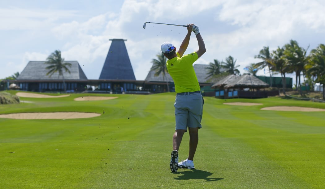 Mike Weir gets in some practice on the 18th hole, with the clubhouse in the distance.