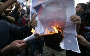 Protesters burn a picture of US President Donald Trump during a protest in the southern Gaza Strip town of Rafah.