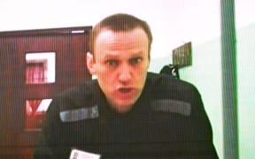 Jailed Russian opposition figure Alexei Navalny is seen on a screen via a video link from his penal colony during court hearings over the extremism criminal case against him at the Russia's Supreme Court in Moscow on June 22, 2023. A Russian court ordered on June 19, 2023, that the trial for Kremlin critic Alexei Navalny be held behind closed doors as he faces extremism charges that could see his time in prison extended for decades. The case comes more than a year into Russia's full-scale offensive in Ukraine, which unleashed an unprecedented crackdown on the Kremlin's critics, with many now in exile or in jail. President Vladimir Putin's most prominent critic is being tried at the maximum security prison where he is jailed: IK-6 penal colony, some 250 kilometres (155 miles) east of Moscow. (Photo by Natalia KOLESNIKOVA / AFP)
