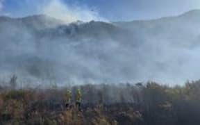 Smoke rises from an inland bush fire bordering the West Coast, with the fire risk continuing to be high.