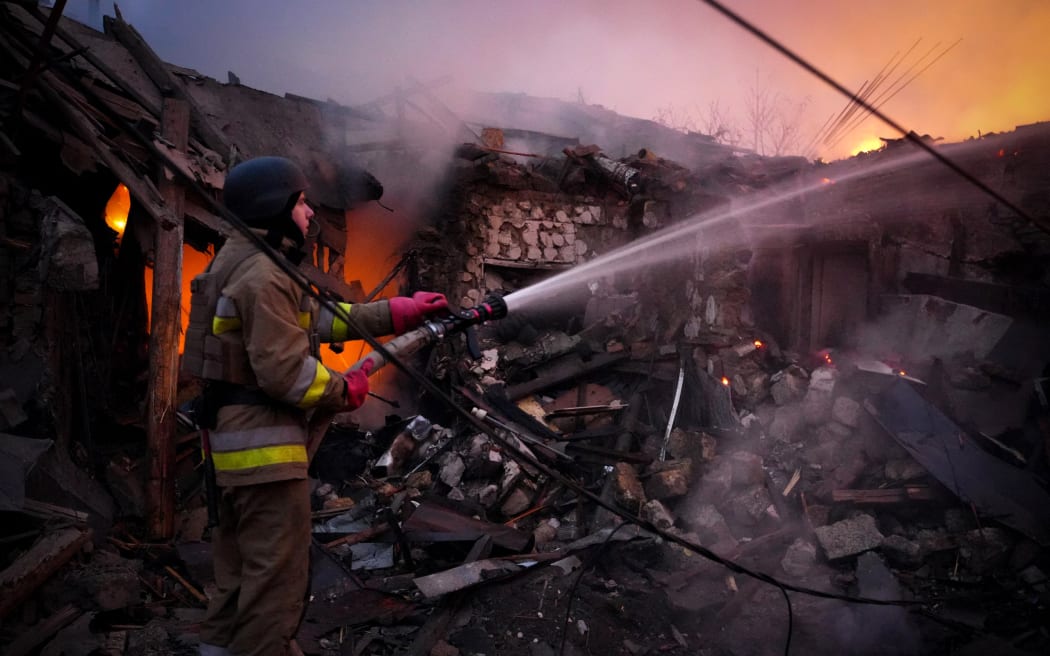 In this handout photograph taken and released by the Ukrainian Emergency Service on November 17, 2024, a Ukrainian rescuer works to extinguish a fire in a building following a drone attack in Mykolaiv. - Ukraine's energy operator DTEK on November 17, 2024 announced "emergency power cuts" in the Kyiv region and two others in the east after authorities revealed Russia had launched a "massive" aerial attack on the energy grid. (Photo by Handout / UKRAINIAN EMERGENCY SERVICE / AFP) / RESTRICTED TO EDITORIAL USE - MANDATORY CREDIT "AFP PHOTO / UKRAINIAN EMERGENCY SERVICE" - NO MARKETING NO ADVERTISING CAMPAIGNS - DISTRIBUTED AS A SERVICE TO CLIENTS