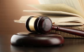 Wooden gavel and books on wooden table,on brown background