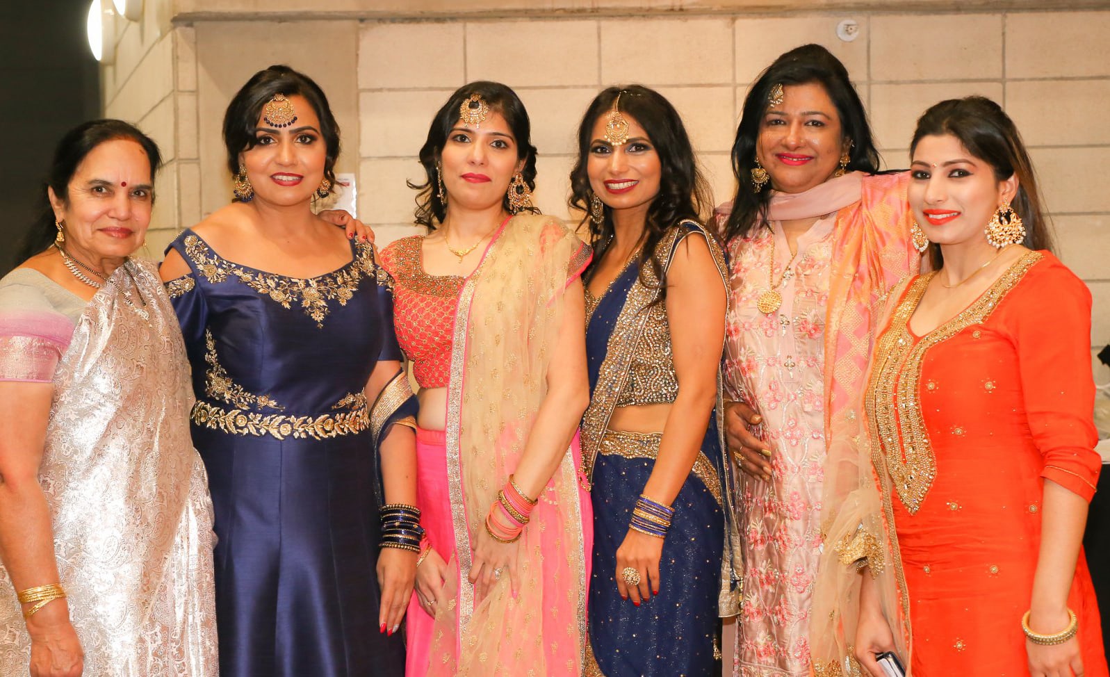 Baljit Dheil (second from left), stands next to Abha Khanna, and Soni Dheil celebrate their culture with other women.