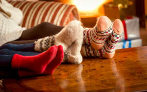 Closeup conceptual photo of family warming feet at fireplace