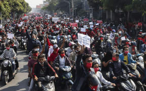 Protesters hold posters during a demonstration against the military coup near the royal palace in Mandalay on February 7, 2021.