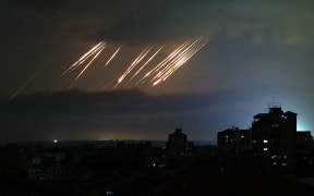 This picture taken from Nuseirat in the central Gaza Strip shows missiles fired from Iran towards Israel pictured in the night sky on June 14, 2025. Israel and Iran exchanged fire on June 14, a day after Israel unleashed an unprecedented aerial bombing campaign that Iran said hit its nuclear facilities, "martyred" top commanders and killed dozens of civilians (Photo by Eyad BABA / AFP)