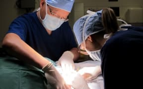 Dr Anthony Yung (left) with registrar Dr Georgina Harvey excising a skin cancer. For Karen Browns dermatology story