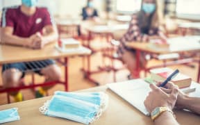 View from the teachers desk of students wearing protective masks against coronavirus disease.