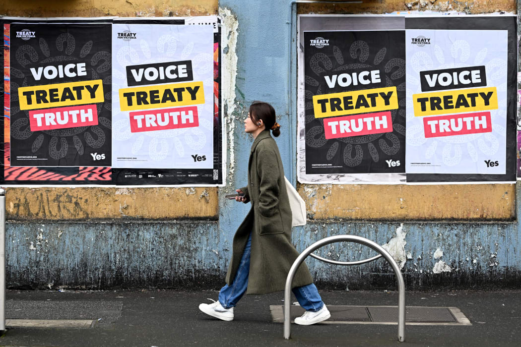 A woman walks past posters advocating for an Aboriginal voice and treaty ahead of an upcoming referendum, in Melbourne on August 30, 2023. Prime Minister Anthony Albanese announced Australia will hold a historic Indigenous rights referendum on October 14 setting up a defining moment in the nation's relationship with its Aboriginal minority. (Photo by William WEST / AFP)