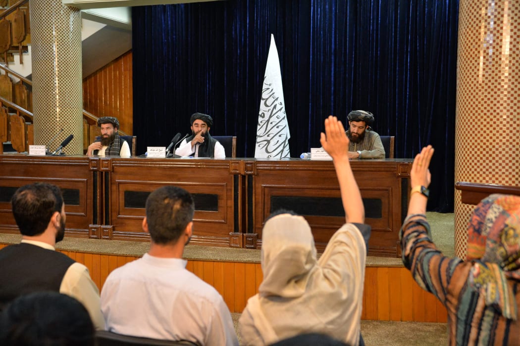 Taliban spokesperson Zabihullah Mujahid (centre) takes questions from journalists during a press conference in Kabul on August 24, 2021.