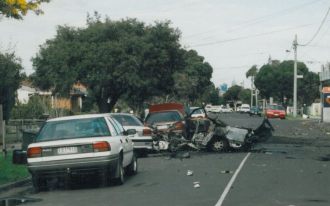 John Furlan's exploded car is seen on a residential street during the day.