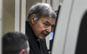 Cardinal George Pell is escorted in handcuffs from the Supreme Court of Victoria in Melbourne on August 21, 2019.