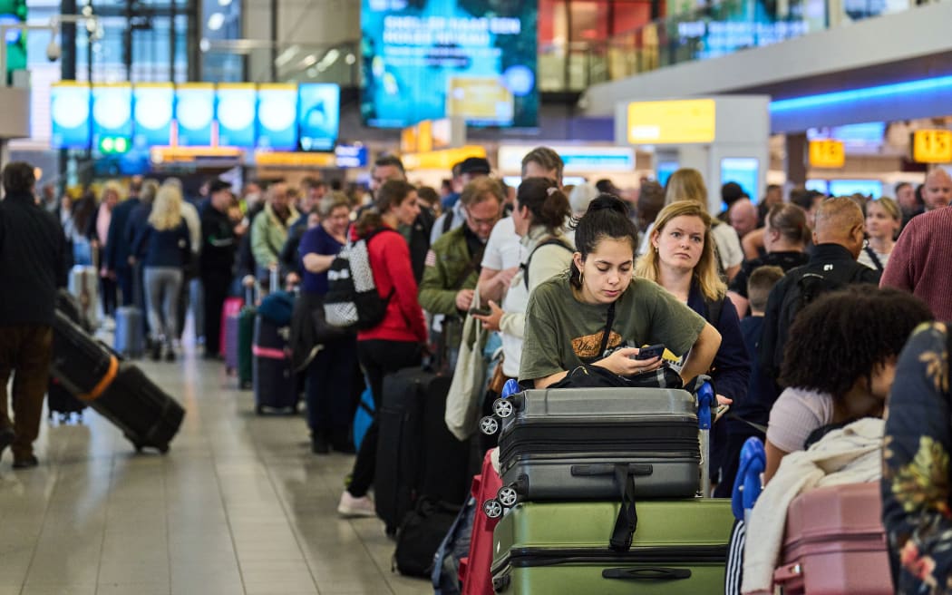 People standing in a queue at Schiphol airport in Netherland as holiday season puts a strain on airlines.