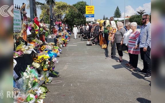 People link arms around NZ mosques during Friday prayers