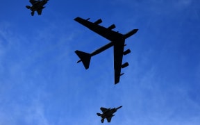 A US B-52 bomber is escorted by two F-15 fighter aircraft during a fly-over at a sports game in Louisiana, on 16 October 2021.