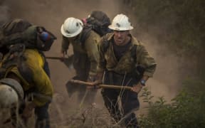 A Hot Shot crew cuts a line among homes at the Thomas Fire in Montecito, California.