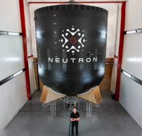 Rocket Lab founder Sir Peter Beck, with the in-development 'Neutron' rocket.